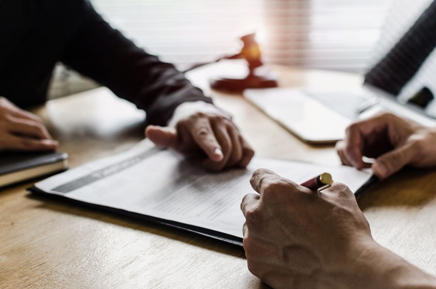 Man signing paper with other business man