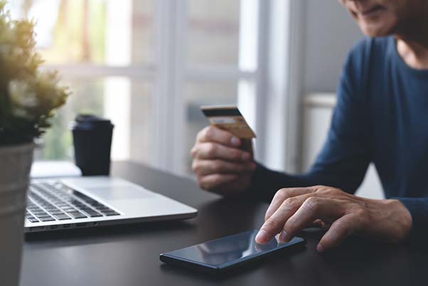 Man using phone while holding credit card