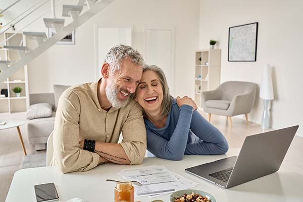 Smiling couples looking at laptop